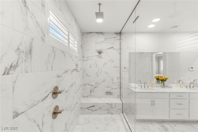 full bathroom with a marble finish shower, double vanity, and marble finish floors
