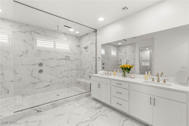 full bath featuring a marble finish shower, marble look tiles, double vanity, and recessed lighting
