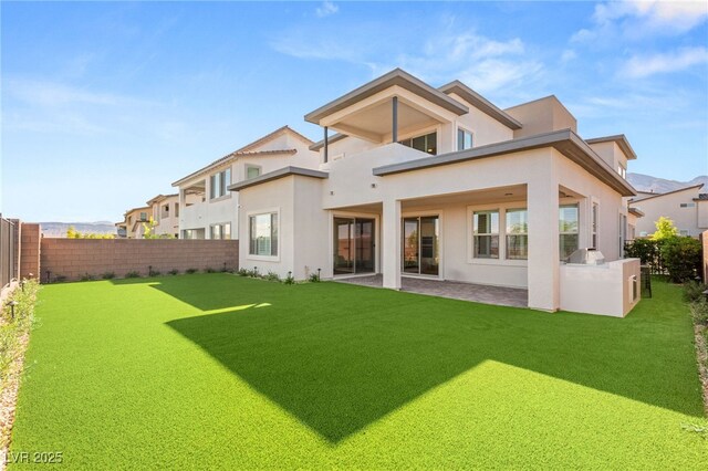 back of property with stucco siding, a balcony, and a patio area