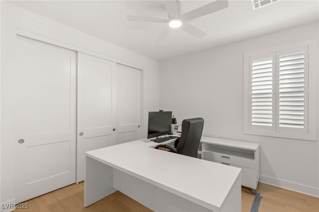 office space with light wood finished floors, a ceiling fan, and baseboards