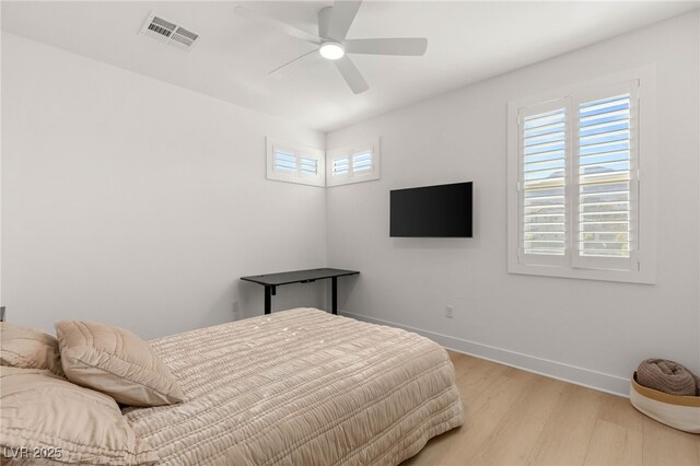 bedroom with light wood-type flooring, baseboards, and a ceiling fan