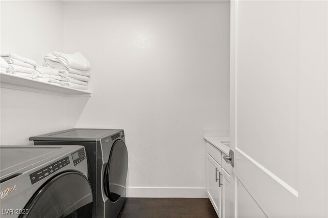 washroom featuring washer and clothes dryer, cabinet space, and baseboards
