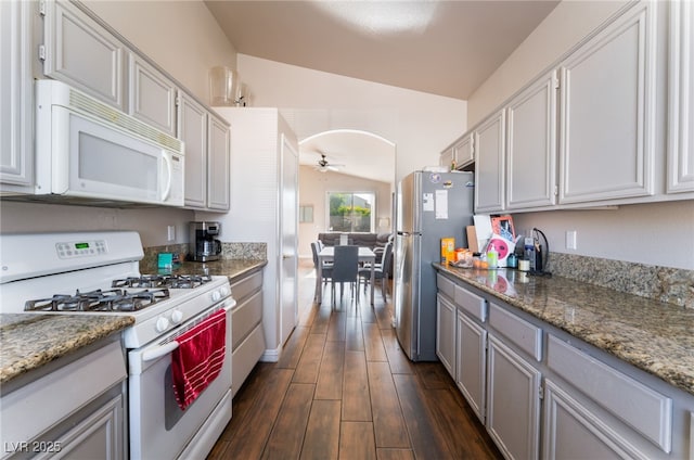 3839 Dusty Glen Ct, North Las Vegas, NV 89032 - kitchen with white appliances, ceiling fan, lofted ceiling, dark wood-type flooring, and arched walkways
