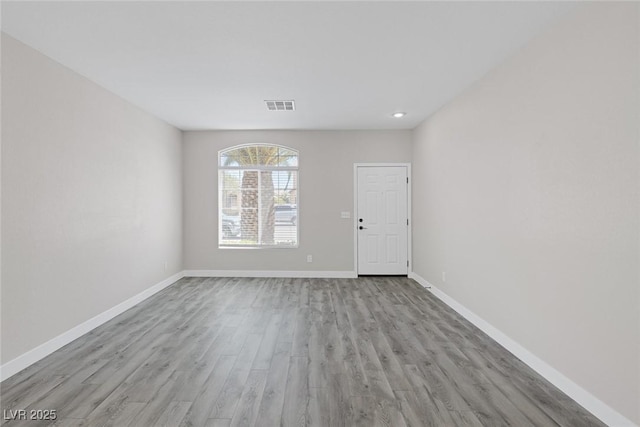 empty room featuring wood finished floors and baseboards