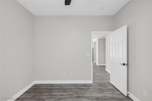 spare room featuring baseboards and wood finished floors