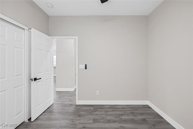 unfurnished bedroom with baseboards, dark wood-style flooring, and ceiling fan