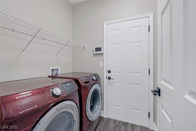 laundry room featuring washing machine and dryer and wood finished floors