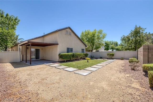 back of house featuring a patio, a fenced backyard, and stucco siding