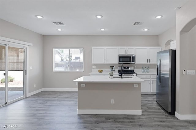 kitchen with stainless steel appliances, light countertops, white cabinetry, and recessed lighting