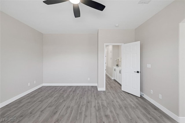 empty room with a ceiling fan, light wood-style floors, and baseboards