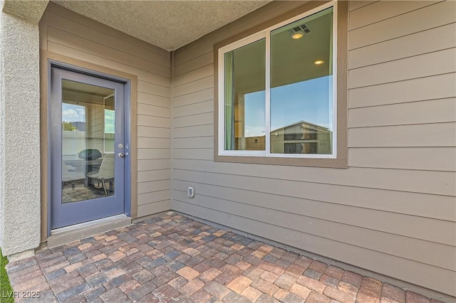 entrance to property featuring a patio area