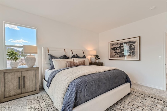 bedroom with light colored carpet and baseboards