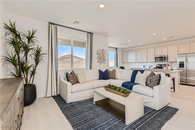 living area featuring recessed lighting and light wood-style floors