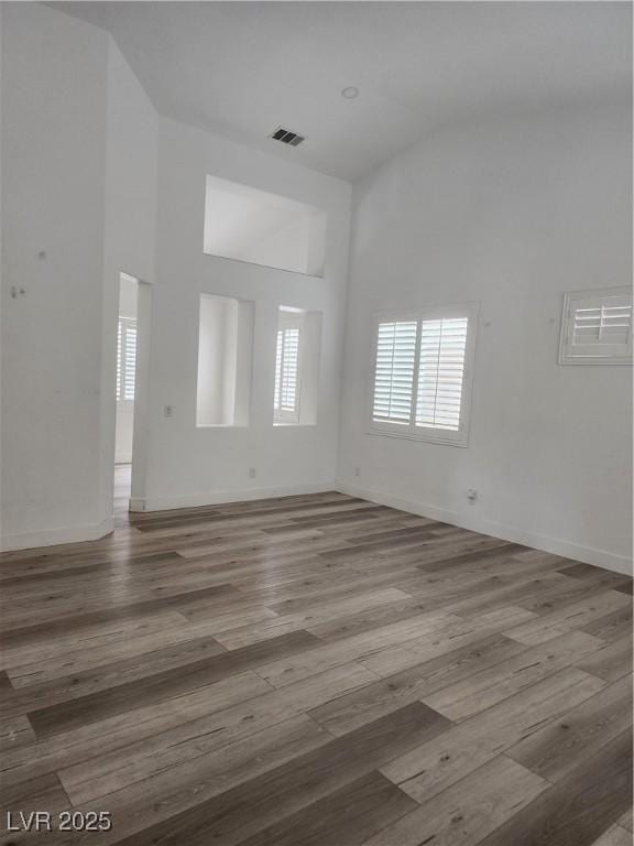 8355 Cabin Peak St, Las Vegas, NV 89123 - unfurnished living room with high vaulted ceiling, wood finished floors, and baseboards