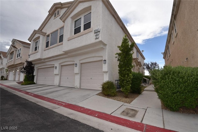 8842 Duncan Barrel Ave Unit 101, Las Vegas, NV 89178 - view of side of property with a garage, stucco siding, and driveway