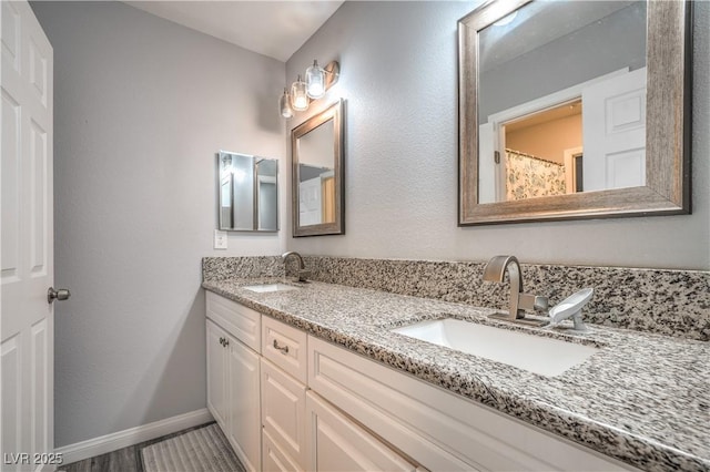 4078 Gold Coast Dr, Las Vegas, NV 89121 - bathroom featuring double vanity and baseboards