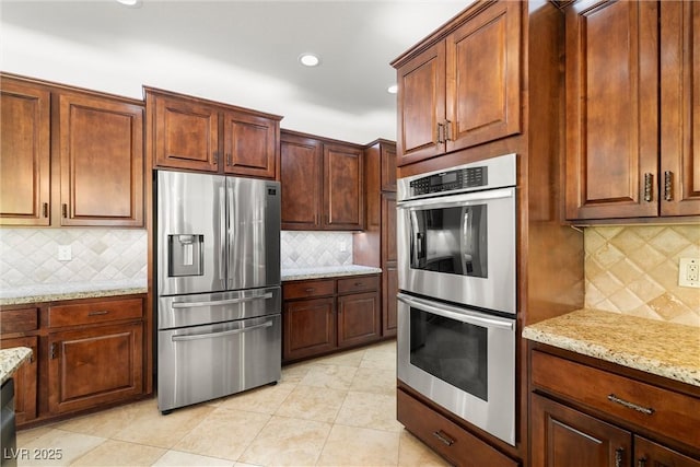 5067 Pensier St, Las Vegas, NV 89135 - kitchen featuring stainless steel appliances, backsplash, light stone counters, recessed lighting, and light tile patterned flooring