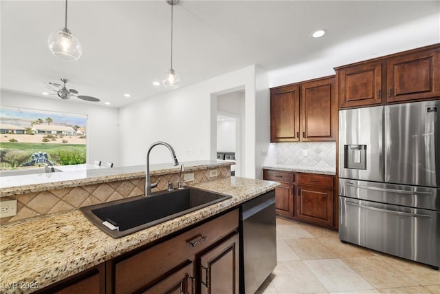 5067 Pensier St, Las Vegas, NV 89135 - kitchen with appliances with stainless steel finishes, tasteful backsplash, light stone countertops, decorative light fixtures, and light tile patterned flooring