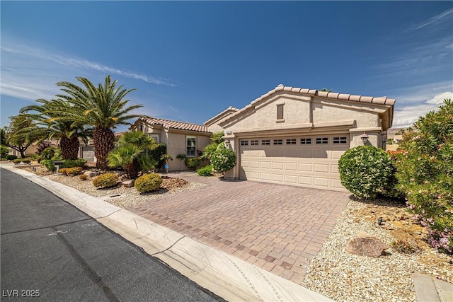 5067 Pensier St, Las Vegas, NV 89135 - view of front of house with decorative driveway, an attached garage, stucco siding, and a tiled roof