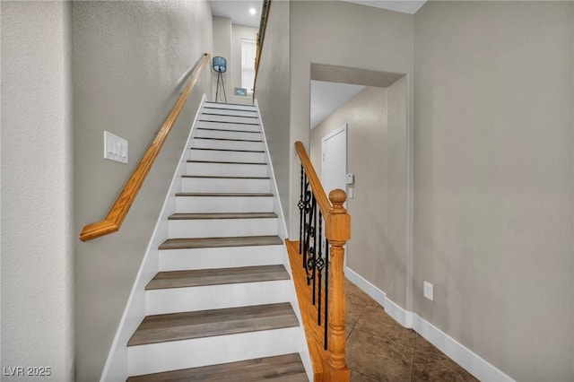 stairway featuring baseboards and tile patterned flooring