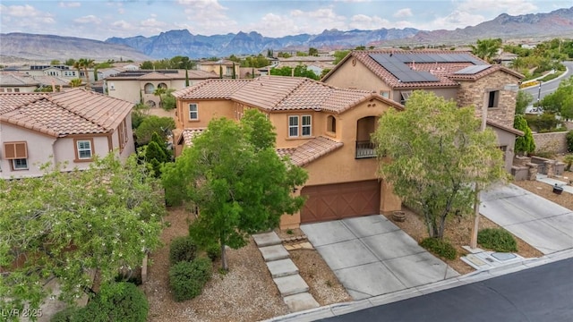 mediterranean / spanish-style home with stucco siding, concrete driveway, a residential view, and solar panels