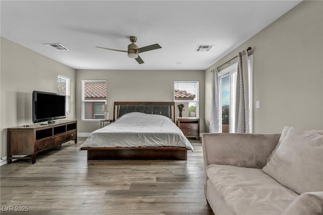 bedroom with wood finished floors, a ceiling fan, and baseboards