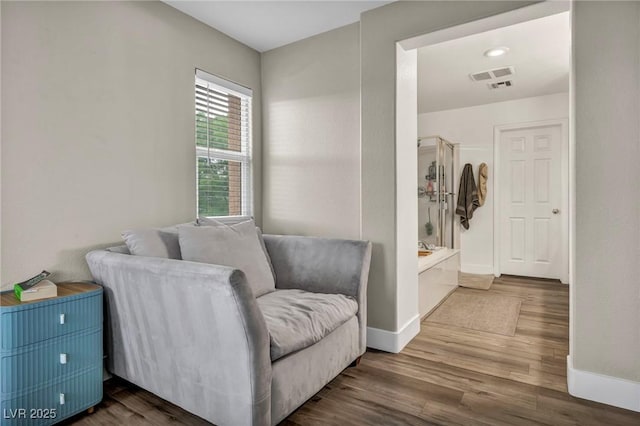living area with baseboards and wood finished floors