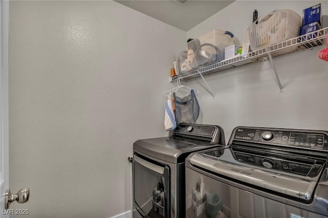 laundry area featuring washing machine and dryer and baseboards