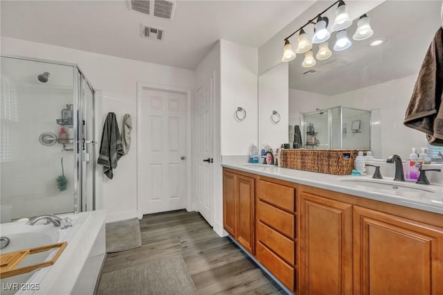 617 Apricot Rose Pl, Las Vegas, NV 89138 - bathroom featuring a stall shower, double vanity, wood finished floors, and a bath