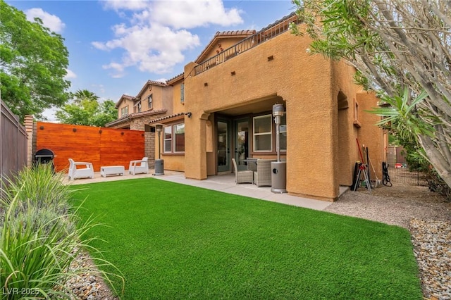 back of property with stucco siding, a patio area, and a tile roof
