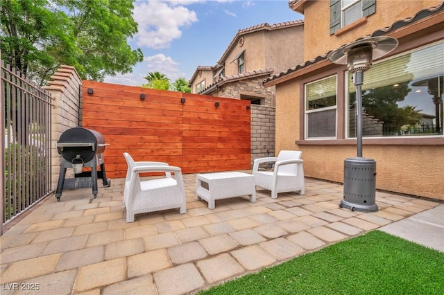 view of patio with fence and a grill