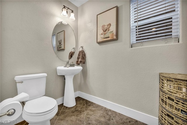 bathroom with tile patterned floors, toilet, and baseboards