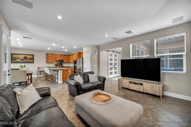 living room featuring baseboards, recessed lighting, a barn door, and light tile patterned flooring