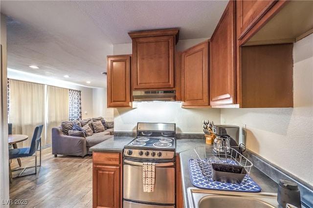 1553 Dorothy Ave Unit 4, Las Vegas, NV 89119 - kitchen with stainless steel electric range oven, under cabinet range hood, dark countertops, light wood-style floors, and recessed lighting