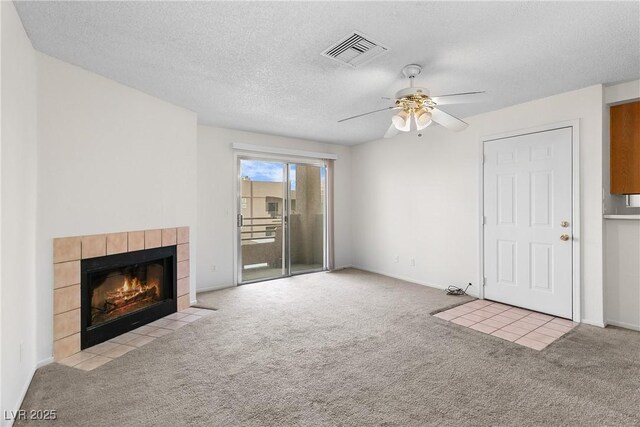 2232 Aspen Mirror Way Unit 202, Laughlin, NV 89029 - unfurnished living room with carpet, a tile fireplace, ceiling fan, a textured ceiling, and baseboards
