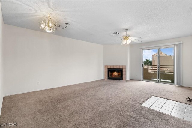 2232 Aspen Mirror Way Unit 202, Laughlin, NV 89029 - unfurnished living room featuring carpet, a textured ceiling, a chandelier, a tile fireplace, and ceiling fan