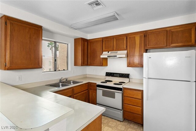2232 Aspen Mirror Way Unit 202, Laughlin, NV 89029 - kitchen with white appliances, a sink, under cabinet range hood, a peninsula, and light countertops