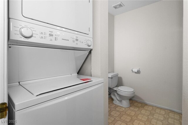 2232 Aspen Mirror Way Unit 202, Laughlin, NV 89029 - bathroom with stacked washer and clothes dryer, tile patterned floors, toilet, and baseboards