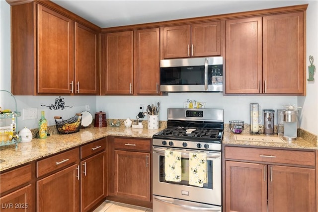 2213 Chandler Ranch Pl, Laughlin, NV 89029 - kitchen featuring stainless steel appliances, light stone countertops, and brown cabinetry