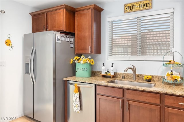 2213 Chandler Ranch Pl, Laughlin, NV 89029 - kitchen featuring appliances with stainless steel finishes, a sink, light stone counters, and brown cabinets