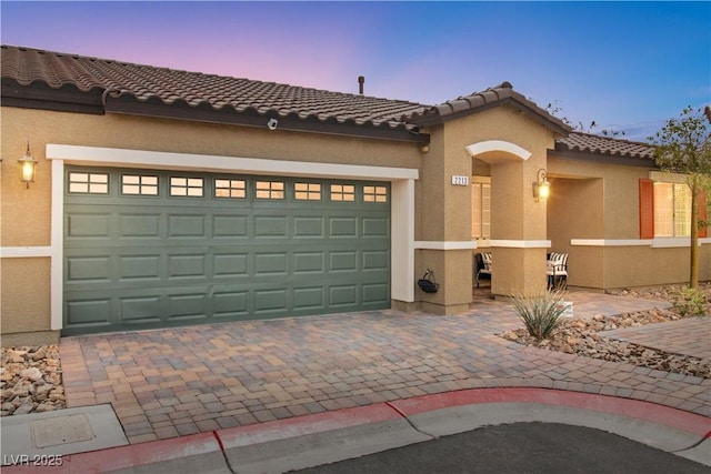 2213 Chandler Ranch Pl, Laughlin, NV 89029 - mediterranean / spanish home with a tiled roof, stucco siding, decorative driveway, and a garage