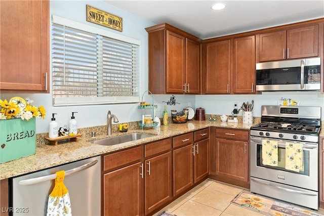 2213 Chandler Ranch Pl, Laughlin, NV 89029 - kitchen featuring appliances with stainless steel finishes, a sink, light stone countertops, light tile patterned floors, and brown cabinets