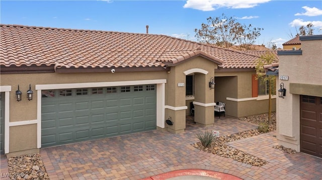 2213 Chandler Ranch Pl, Laughlin, NV 89029 - mediterranean / spanish home featuring stucco siding, a tile roof, a garage, and decorative driveway