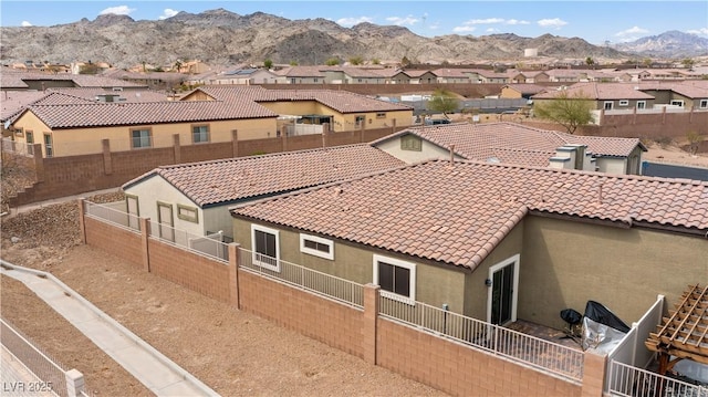 2213 Chandler Ranch Pl, Laughlin, NV 89029 - rear view of property with a residential view, a tiled roof, stucco siding, a fenced backyard, and a mountain view