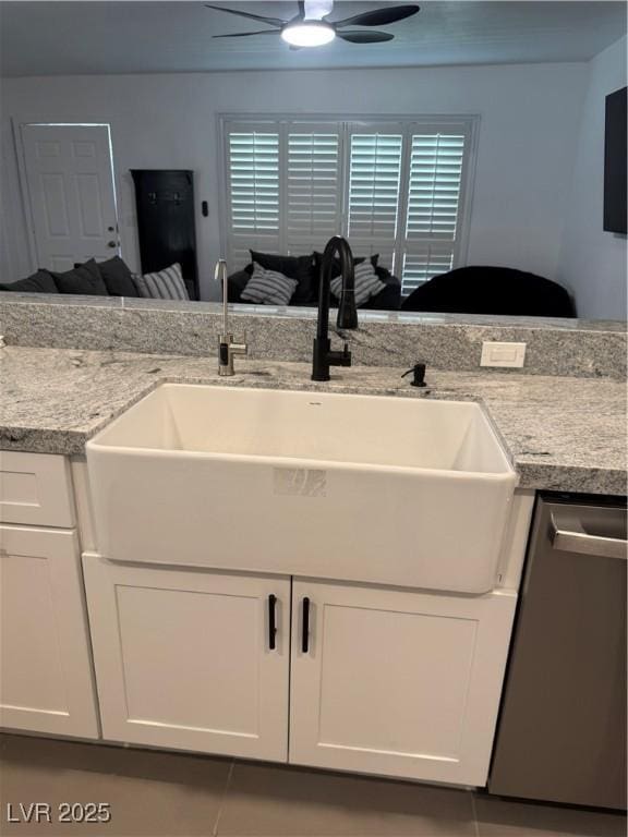 kitchen featuring stainless steel dishwasher, a sink, ceiling fan, and white cabinets