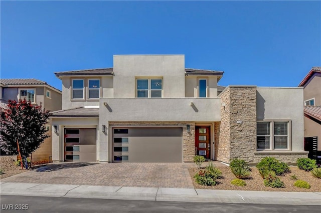 2579 Speyburn Ave, Henderson, NV 89044 - view of front facade with a garage, stone siding, stucco siding, decorative driveway, and a tile roof