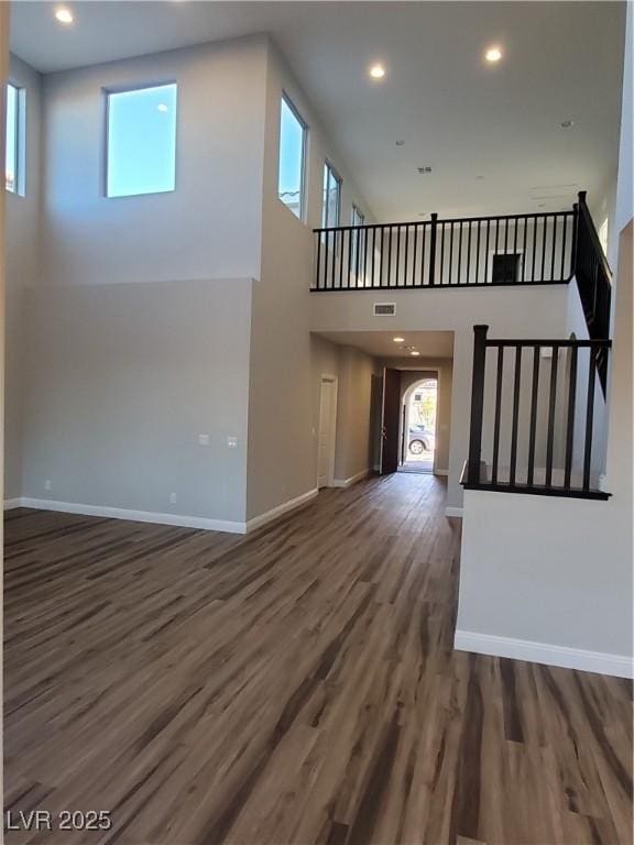 1027 Cambridge Park St, Las Vegas, NV 89148 - unfurnished living room with wood finished floors, baseboards, a towering ceiling, and recessed lighting