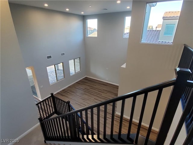 1027 Cambridge Park St, Las Vegas, NV 89148 - stairway featuring recessed lighting, baseboards, wood finished floors, and a towering ceiling