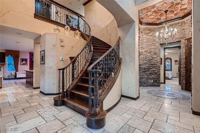 7501 Midnight Rambler St, Las Vegas, NV 89149 - stairs featuring stone tile floors, a chandelier, baseboards, crown molding, and arched walkways