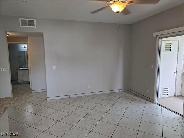 unfurnished room featuring a ceiling fan, light tile patterned floors, and baseboards